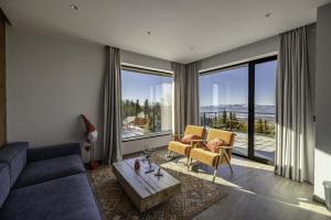 a living room with a couch and a large window at Chalet 1600 Kopaonik & Spa in Kopaonik
