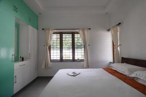 a bedroom with a large bed and a window at Elora Plantation Villa By Cluster cloud in Idukki +27 photos