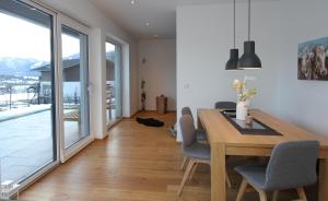 a dining room with a wooden table and chairs at Daslichtenberg Eastside in Saalfelden am Steinernen Meer