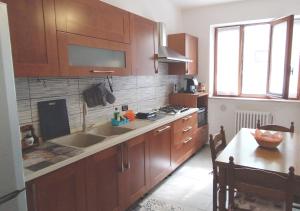 a kitchen with wooden cabinets and a sink and a table at Appartamento ZOIA in Crevacuore