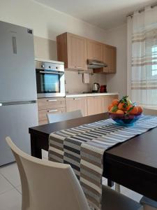 a kitchen with a table with a bowl of fruit on it at Stella Maris - Private Apartment in Bari +18 photos