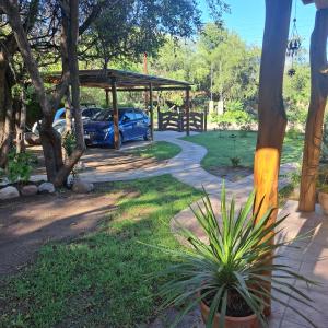 a blue car parked under a pavilion in a yard at Departamento Las Rosas in Villa de Las Rosas