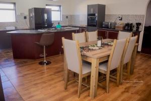a kitchen with a wooden table with chairs and a counter at Desert Place Self-catering cc in Lüderitz