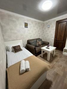 een slaapkamer met een bed, een bank en een tafel bij garden and panorama in Mtskheta