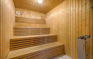 a sauna with wooden walls and benches in a room at Holiday Home Kirstinevej Hvide Sande V in Bjerregård +11 photos