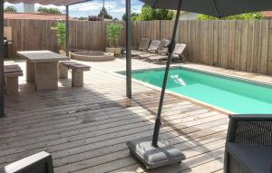 a swimming pool with an umbrella and a table and chairs at Beautiful Home In Ares in Arès +15 photos