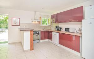 a kitchen with red cabinets and white appliances at Les Piboules in Arles