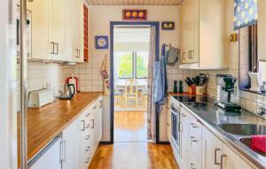 トレコーブにある6 Bedroom Stunning Home In Torekovの白いキャビネットとオープンドア付きのキッチン