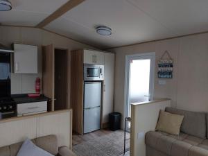 pequeña sala de estar con sofá y cocina en Gateway to Cornwall, en St Austell
