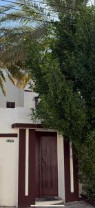 a building with a brown door and a tree at شقه كبيرة in Hail