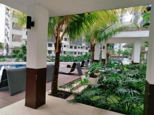 a courtyard with palm trees and a swimming pool at SMDC VINE Residence Rilakkuma-theme 2BR w Balcony in Manila