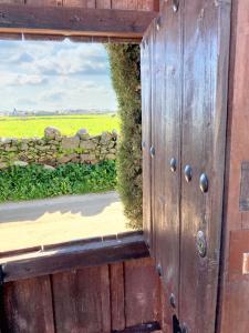 a wooden door with a window looking out at a field at Comfortable House with Shared Pool in Alcaracejos in Alcaracejos