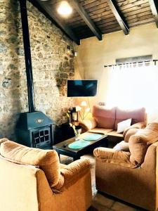a living room with couches and a stone wall at Comfortable House with Shared Pool in Alcaracejos in Alcaracejos
