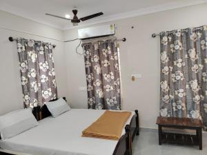 a bedroom with a bed with curtains and a ceiling at YU Stay - Kanipakam in Kanipakam
