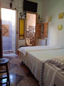 um quarto com 2 camas e uma casa de banho com WC. em Pousada Fonte Viva em Lavras Novas mais 18 fotografias