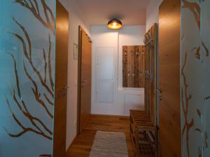 een hal met een deur naar een kamer met een spiegel bij Kitzb heler Alpenlodge Top A6 with private panoramic sauna in Mittersill