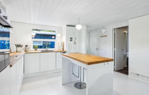 Una cocina con gabinetes blancos y una encimera de madera. en Awesome Home In Ebeltoft With Sauna, en Ebeltoft 18 fotos más