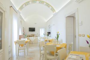 a dining room with tables and white chairs at Dimora Dell'Osanna in Carovigno
