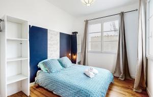 ein Schlafzimmer mit einem blau-weißen Bett und einem Fenster in der Unterkunft Lovely Home In Royan With Wifi in Royan