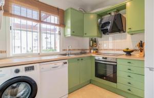 una cucina con armadi verdi e una lavatrice di Awesome Home In San Luis De Sabinillas a San Luis de Sabinillas