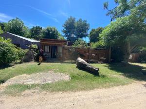 a log sitting in the yard of a house at Cabañas el descanso in Chascomús