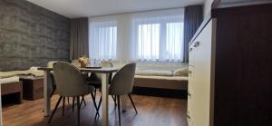a room with a table and chairs and a bed at Penzión LABA in Trebišov