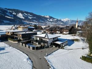 una città innevata con le montagne sullo sfondo di Ferienwohnung Gartner a Uderns
