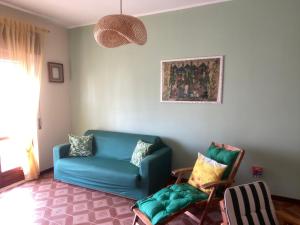 a living room with a blue couch and two chairs at Raggio di Sole Casa vacanze Caulonia Marina a 800m dalla spiaggia in Caulonia Marina