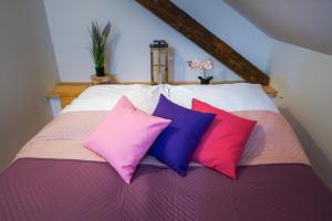 a bed with three different colored pillows on it at Lawki Booking in Ławki