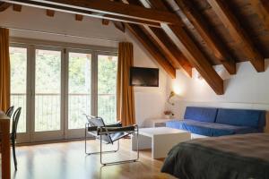 a bedroom with a bed and a couch at Albergo Diffuso Comeglians in Comeglians