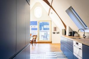 a kitchen with blue cabinets and a dining room at Central Art Apartment - Nieuwmarkt area in Amsterdam
