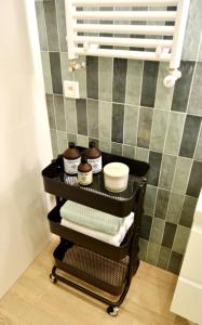 a black cart with towels on it in a bathroom at Apartament Syberka in Będzin