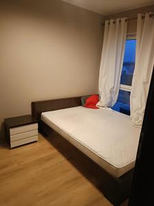a small bedroom with a bed with a window at Apartament Malbork in Malbork