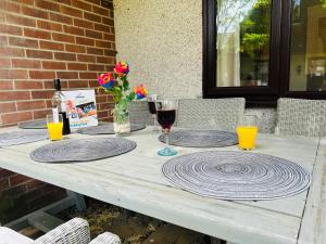 a wooden table with glasses of wine and flowers on it at Trevithick 46 in Hayle