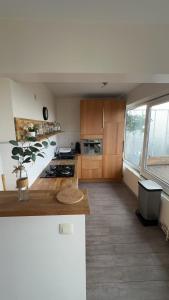a kitchen with wooden cabinets and a large window at Air Bey Penthouse in Brussels