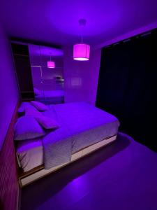 a purple bedroom with a bed with purple lighting at Air Bey Penthouse in Brussels