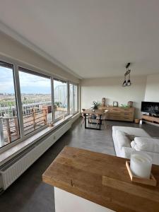 a living room with a couch and a large window at Air Bey Penthouse in Brussels