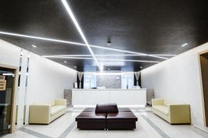 a lobby with a couch and two chairs and a table at Algoritm Hotel in Tyumen