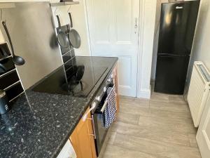 a kitchen with a black counter top and a refrigerator at Central Halifax Work & Retreat Base - Two bedroom house - sleeps up to 4 - free parking and internet in Halifax
