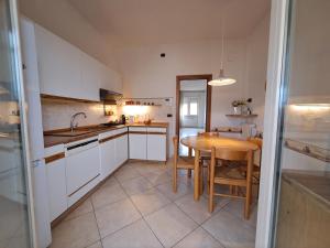 Una cocina con gabinetes blancos y una mesa de madera. en 2 Giugno House, en Bari