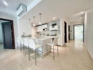 une cuisine avec un comptoir blanc et des tabourets dans l'établissement Modern Comfort - Spacious 2BR in Walled City, à Carthagène des Indes