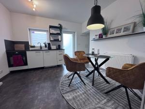 a living room with a table and chairs and a kitchen at Barrierefrei - 24Std-CHECK-IN kontaktlos - Kingsize Bed - W-LAN - Parkplatz W 3 in Bückeburg