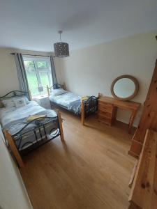 Un dormitorio con dos camas y un espejo en la pared. en Welcoming 4 bedroom townhouse with free parking on premises, en Lisnaskea