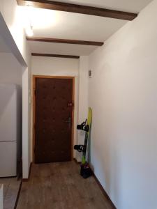 una habitación con una puerta y una tabla de snowboard apoyada en una pared en Straja Apartament, en Lupeni