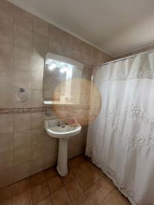 een badkamer met een wastafel en een douchegordijn bij Casa Ganesha Chapadmalal in Chapadmalal