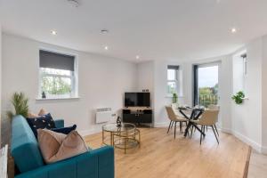 ein Wohnzimmer mit einem blauen Sofa und einem Tisch in der Unterkunft Modern 2-Bedroom Apartment, Leatherhead, Sleeps 4 in Leatherhead