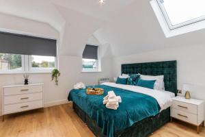 Schlafzimmer mit einem großen Bett mit blauer Tagesdecke in der Unterkunft Modern 2-Bedroom Apartment, Leatherhead, Sleeps 4 in Leatherhead