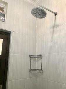 a shower with a shower head in a bathroom at Grania Homestay in Margasari +13 photos