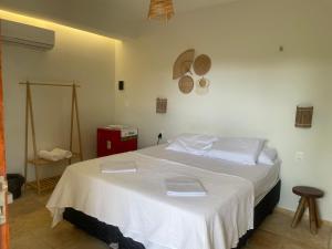 a bedroom with a bed with two white towels on it at Vila Ybirá in Taíba +10 photos