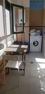 a kitchen with a table and a washing machine at Disfruta el Puertito de Güímar in Puertito de Güímar